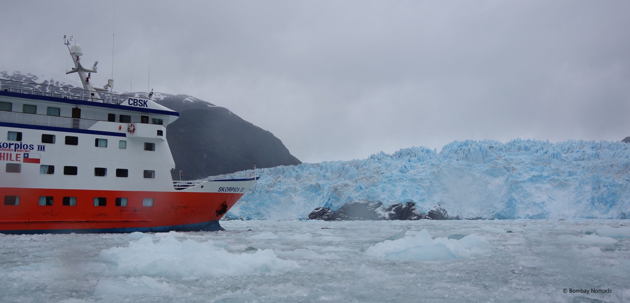 A large blue glacier in Patagonia with a cruise ship nearby